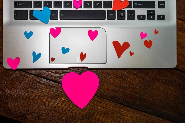 Heart shaped paper cut out on keyboard, love message and Valenti