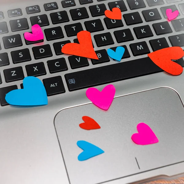 Heart shaped paper cut out on keyboard, love message and Valenti