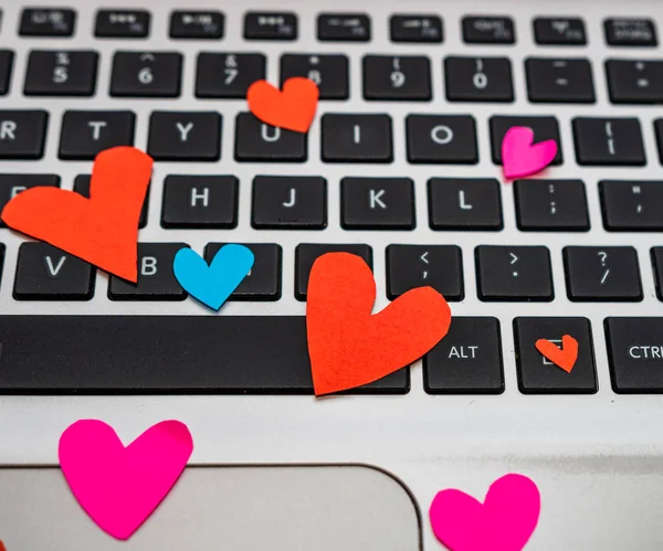 Heart shaped paper cut out on keyboard, love message and Valenti