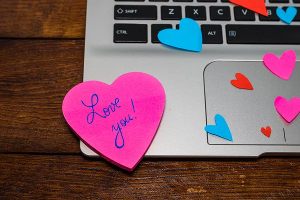 Heart shaped paper cut out on keyboard, love message and Valenti
