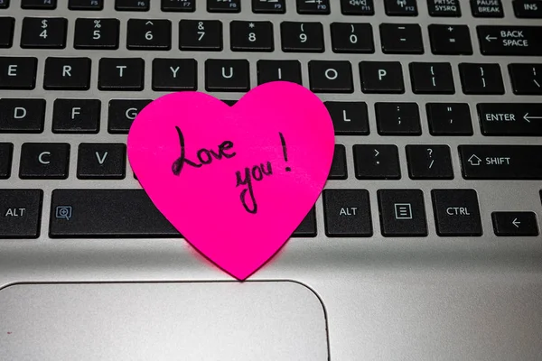 Heart shaped paper cut out on keyboard, love message and Valenti