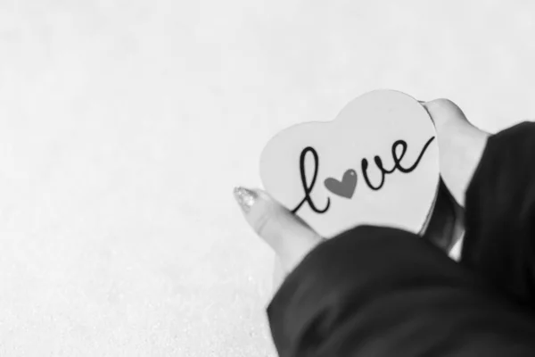 Woman hand holding a white heart with love writing. Valentines day concept, a symbol of love — 스톡 사진