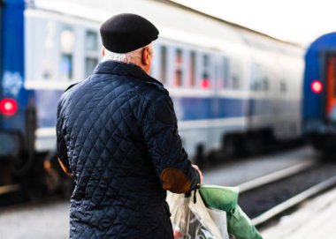 Travelers and commuters waiting for a train on the platform of B