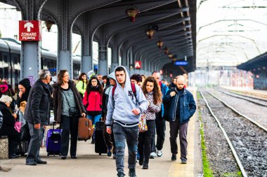 Travelers and commuters waiting for a train on the platform of B