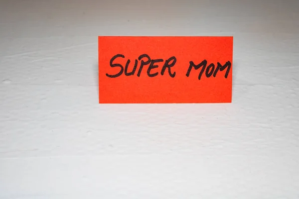 Super mamá escribiendo texto de amor para la madre en papel. Etiqueta con —  Fotos de Stock