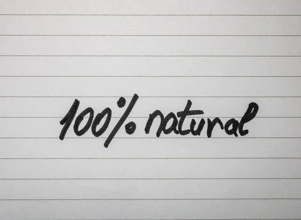 Escribiendo 100% natural en etiqueta blanca sobre fondo blanco . — Foto de Stock