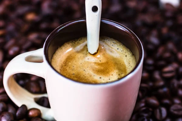 Close up de xícara de café, grãos de café torrados no backgroun vermelho — Fotografia de Stock