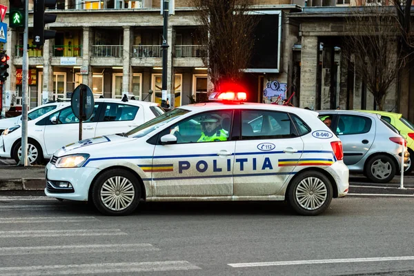 Coche de policía con las luces parpadeando en un cruce en el centro de Bu —  Fotos de Stock