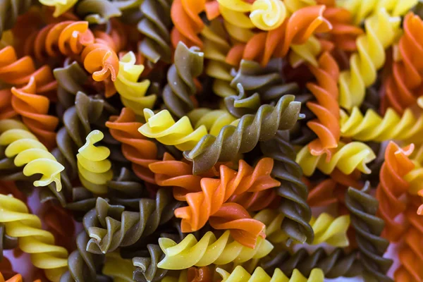 Composition of raw pasta uncooked tricolore fusilli, pasta twist