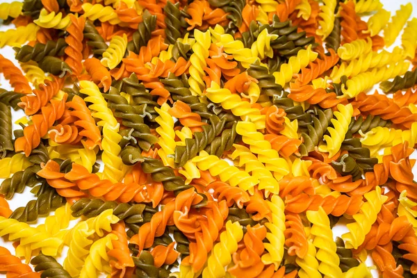 Composition of raw pasta uncooked tricolore fusilli, pasta twist