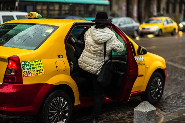 Üzletasszony taxival jár és beszáll. Bukarest, Romani — Stock Fotó