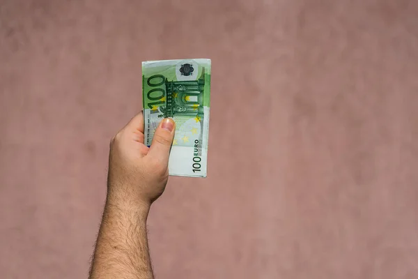 Mão segurando e mostrando o dinheiro do euro ou dando dinheiro. Dinheiro mundial — Fotografia de Stock