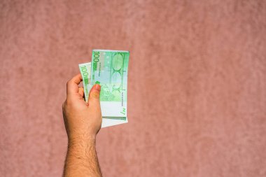El ele tutuşup para göstermek ya da para vermek. Dünya parası
