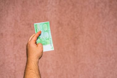El ele tutuşup para göstermek ya da para vermek. Dünya parası