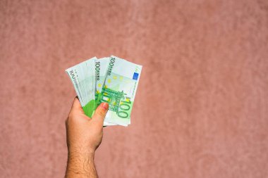 El ele tutuşup para göstermek ya da para vermek. Dünya parası