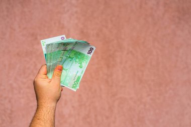 El ele tutuşup para göstermek ya da para vermek. Dünya parası