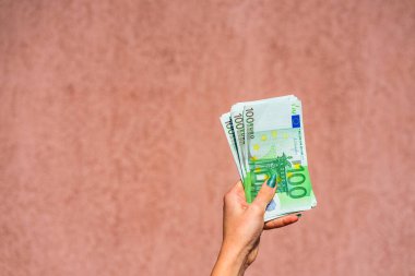El ele tutuşup para göstermek ya da para vermek. Dünya parası