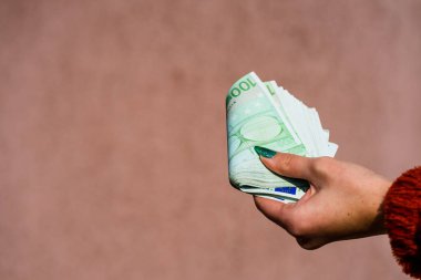 El ele tutuşup para göstermek ya da para vermek. Dünya parası