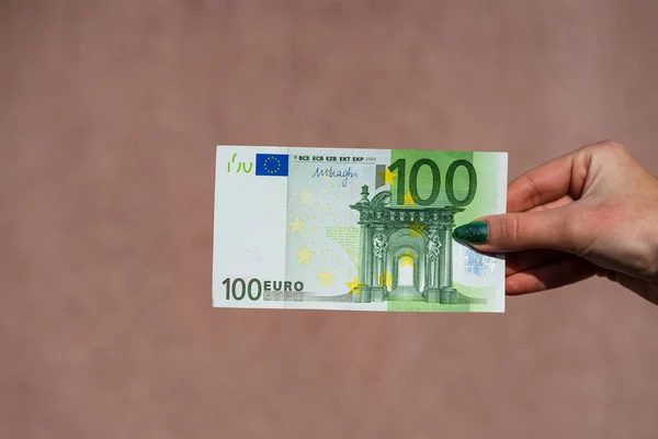 Mão segurando e mostrando o dinheiro do euro ou dando dinheiro. Dinheiro mundial — Fotografia de Stock