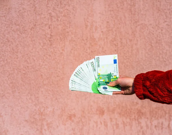 Mão segurando e mostrando um fã de dinheiro em euros ou dando dinheiro. O quê? — Fotografia de Stock