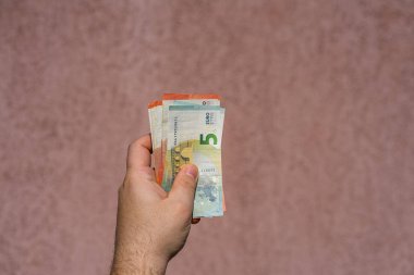 Avro parasını gösteren ve bahşiş, maaş gibi para veren ya da alan el ele tutuşmalar. 5 ve 10 EURO banknotları EUR izole edilmiş. Zengin iş adamları kavramı, para biriktirmek ya da harcamak.