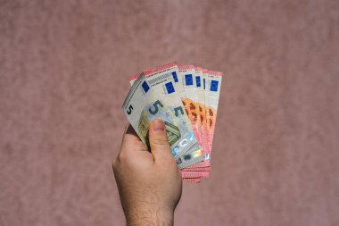 Avro parasını gösteren ve bahşiş, maaş gibi para veren ya da alan el ele tutuşmalar. 5 ve 10 EURO banknotları EUR izole edilmiş. Zengin iş adamları kavramı, para biriktirmek ya da harcamak.