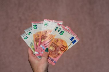 Avro parasını gösteren ve bahşiş, maaş gibi para veren ya da alan el ele tutuşmalar. 5 ve 10 EURO banknotları EUR izole edilmiş. Zengin iş adamları kavramı, para biriktirmek ya da harcamak.