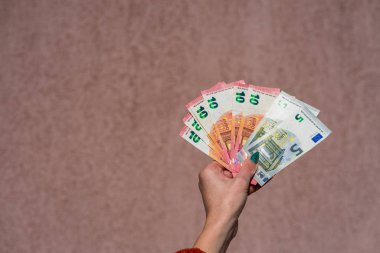 Avro parasını gösteren ve bahşiş, maaş gibi para veren ya da alan el ele tutuşmalar. 5 ve 10 EURO banknotları EUR izole edilmiş. Zengin iş adamları kavramı, para biriktirmek ya da harcamak.