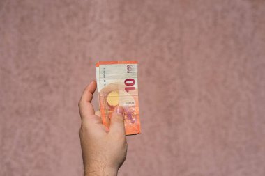 Avro parasını gösteren ve bahşiş, maaş gibi para veren ya da alan el ele tutuşmalar. 10 EURO banknotu EUR izole edilmiş. Zengin iş adamları kavramı, para biriktirmek ya da harcamak.