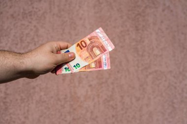 Avro parasını gösteren ve bahşiş, maaş gibi para veren ya da alan el ele tutuşmalar. 10 EURO banknotu EUR izole edilmiş. Zengin iş adamları kavramı, para biriktirmek ya da harcamak.