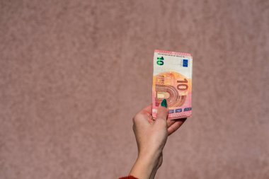 Avro parasını gösteren ve bahşiş, maaş gibi para veren ya da alan el ele tutuşmalar. 10 EURO banknotu EUR izole edilmiş. Zengin iş adamları kavramı, para biriktirmek ya da harcamak.