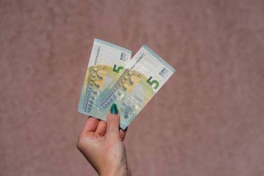 Avro parasını gösteren ve bahşiş, maaş gibi para veren ya da alan el ele tutuşmalar. 5 Avro banknotları izole edildi. Zengin iş adamları kavramı, para biriktirmek ya da harcamak.