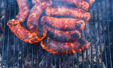 Kömür mangalında ızgara domuz eti ve sosis. Lezzetli barbekü, yemek konsepti, ızgaradaki yemek ve ızgaradaki yemeğin ayrıntıları.