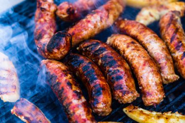 Kömür mangalında ızgara domuz eti ve sosis. Lezzetli barbekü, yemek konsepti, ızgaradaki yemek ve ızgaradaki yemeğin ayrıntıları.
