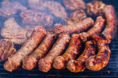 Kömür mangalında ızgara domuz eti ve sosis. Lezzetli barbekü, yemek konsepti, ızgaradaki yemek ve ızgaradaki yemeğin ayrıntıları.
