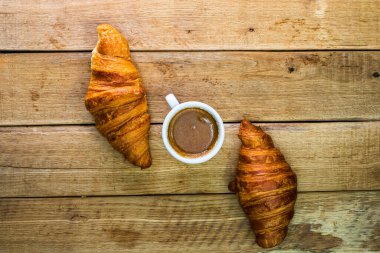 Taze kruvasan, puf böreği ve ahşap masada bisküvi. Kahve, yemek ve kahvaltı konsepti. Tatlılar, taze hamur işleri ve kahve. Üst görünüm ve kopyalama alanı