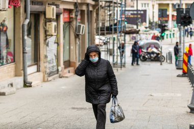 Covid-19 grip virüsü Avrupa 'da yayılıyor. Coronavirüs, grip virüsleri ve hastalıklara karşı maske takan insanlar. Sağlık sigortası konsepti. Bükreş, Romanya, 2020 'de kamusal alanlarda yüzü cerrahi maske takan bir kadın