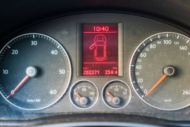 Hız göstergesi ve açık kapı göstergesi olan tozlu araç paneli izole edildi.