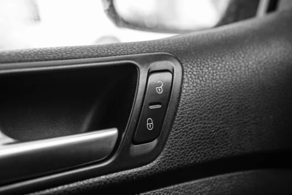 Close up photo inside a car, door lock buttons.