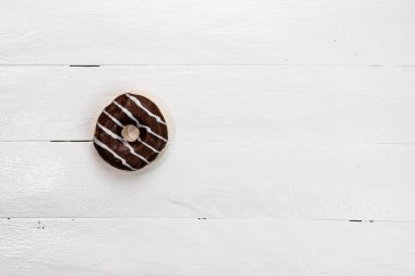 Beyaz ahşap masada renkli çörekler. Şekerli, şekerli, şekerli, şekerli, şekerli. Kopyalama alanı olan üst görünüm