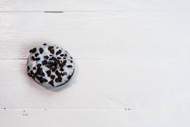 Beyaz ahşap masada renkli çörekler. Şekerli, şekerli, şekerli, şekerli, şekerli. Kopyalama alanı olan üst görünüm
