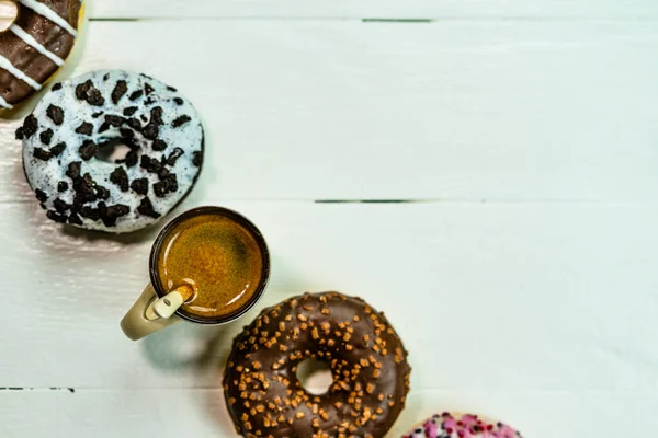 Красочные Пончики Чашка Кофе Белом Деревянном Столе Сладкая Выпечка Посыпанным — стоковое фото