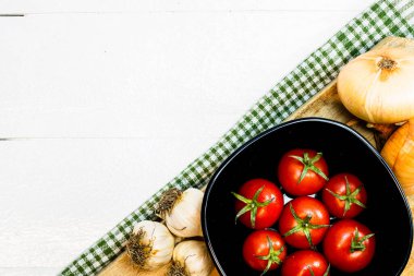 En iyi soğan manzarası, sarımsak ve taze kiraz domatesleri kırsal beyaz ahşap bir masada. Malzemeler ve gıda konsepti