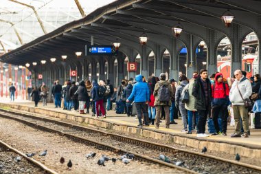 Bükreş 'teki Bükreş Kuzey Tren İstasyonu' nun (Gara de Nord Bükreş) tren peronunda tren bekleyen gezginler ve banliyö sakinleri, 2020