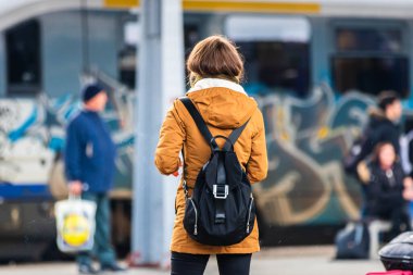 Romanya 'nın Bükreş kentindeki Bükreş Kuzey Demiryolu İstasyonu' nun (Gara de Nord Bükreş) tren peronunda bavul ve sırt çantası taşıyan gezginler ve banliyö yolcuları görülüyor.