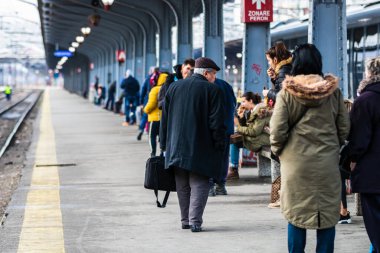Romanya 'nın Bükreş kentindeki Bükreş Kuzey Demiryolu İstasyonu' nun (Gara de Nord Bükreş) tren peronunda bavul ve sırt çantası taşıyan gezginler ve banliyö yolcuları görülüyor.