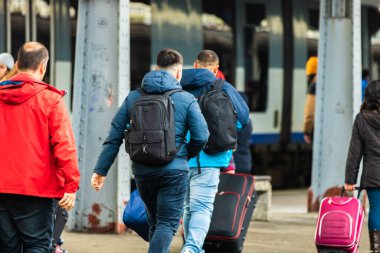 Romanya 'nın Bükreş kentindeki Bükreş Kuzey Demiryolu İstasyonu' nun (Gara de Nord Bükreş) tren peronunda bavul ve sırt çantası taşıyan gezginler ve banliyö yolcuları görülüyor.