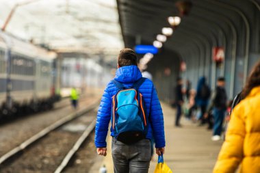 Romanya 'nın Bükreş kentindeki Bükreş Kuzey Demiryolu İstasyonu' nun (Gara de Nord Bükreş) tren peronunda bavul ve sırt çantası taşıyan gezginler ve banliyö yolcuları görülüyor.