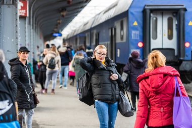 Bükreş 'teki Bükreş Kuzey Tren İstasyonu' nun (Gara de Nord Bükreş) tren peronunda tren bekleyen gezginler ve banliyö sakinleri, 2020