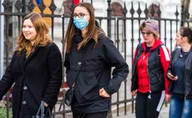 Covid-19 grip virüsü Avrupa 'da yayılıyor. Coronavirus 'a karşı tıbbi maske takan insanlar. Sağlık sigortası konsepti. Bükreş, Romanya, 2020 'de kamusal alanlarda yüzü cerrahi maske takan bir kadın